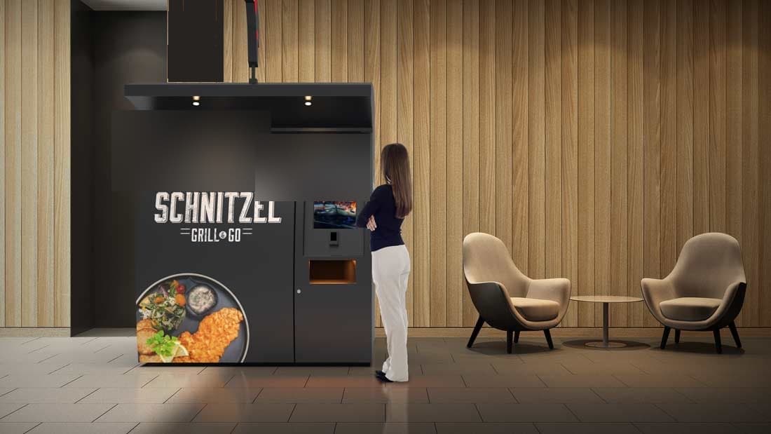 Een bezoeker bestelt bij een onbemande vendingmachine met touchscreen in een lounge
